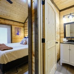 Bed beside French doors, with a small vanity at right