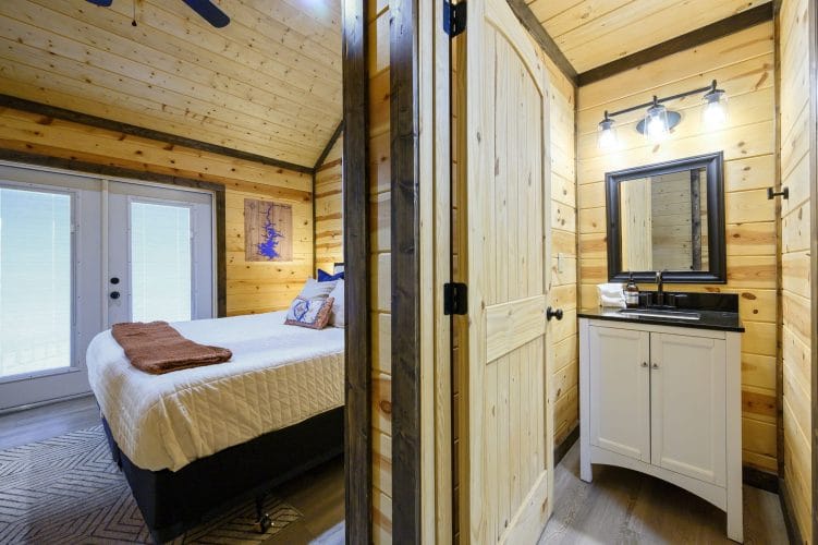 Bed beside French doors, with a small vanity at right