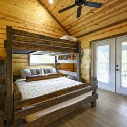 Dark wood bunk bed with French doors to a balcony