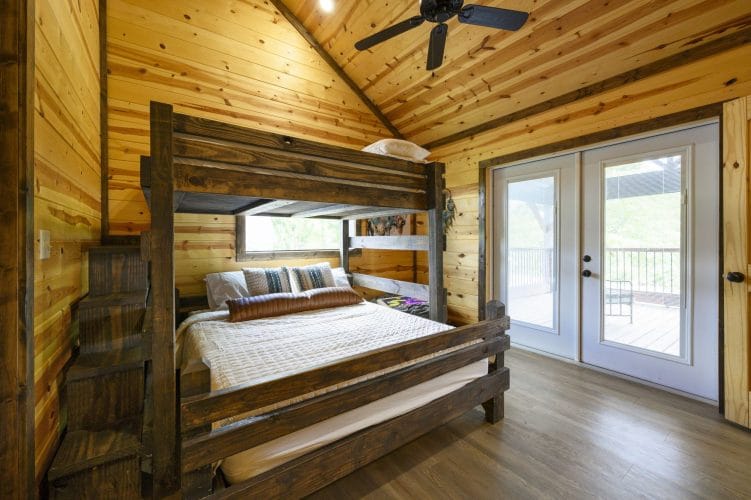 Dark wood bunk bed with French doors to a balcony