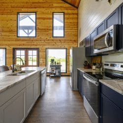 Kitchen with a marble-look island, navy cabinets and French doors to the porch