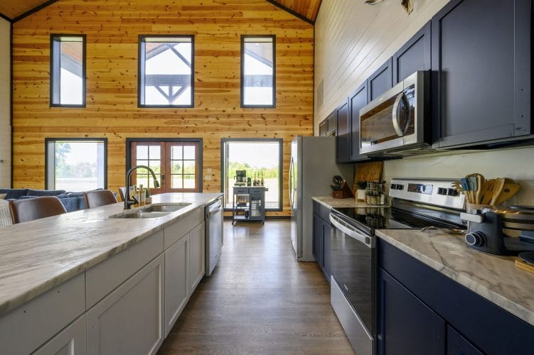 Kitchen with a marble-look island, navy cabinets and French doors to the porch