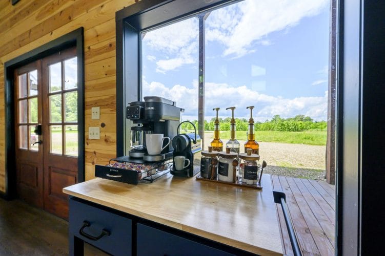 Coffee station by a window with a coffee maker and pod drawer, looking out over a field
