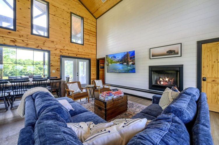 Blue sectional facing a gas fireplace and a wall TV