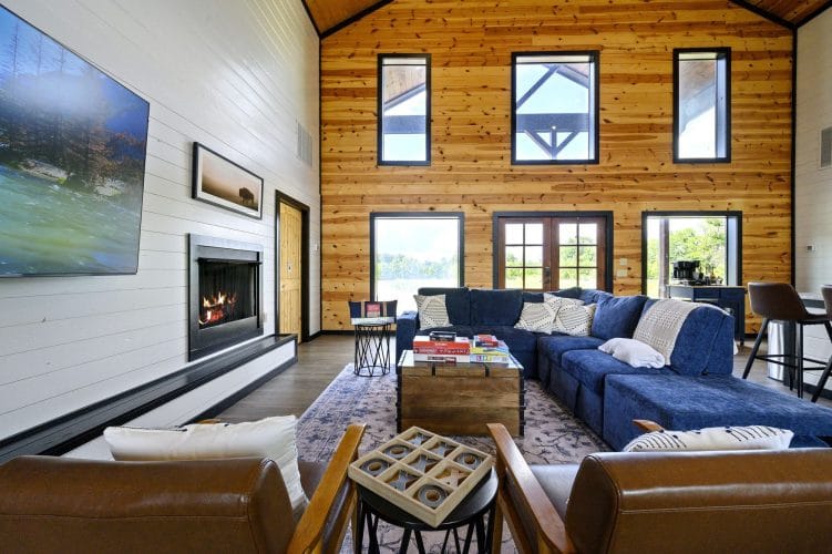 Sectional and leather chairs facing the fireplace, with the TV at left