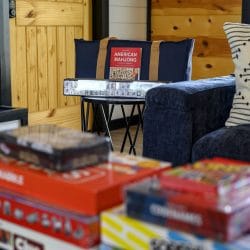 Close view of board games and an American Mahjong set beside a blue sofa