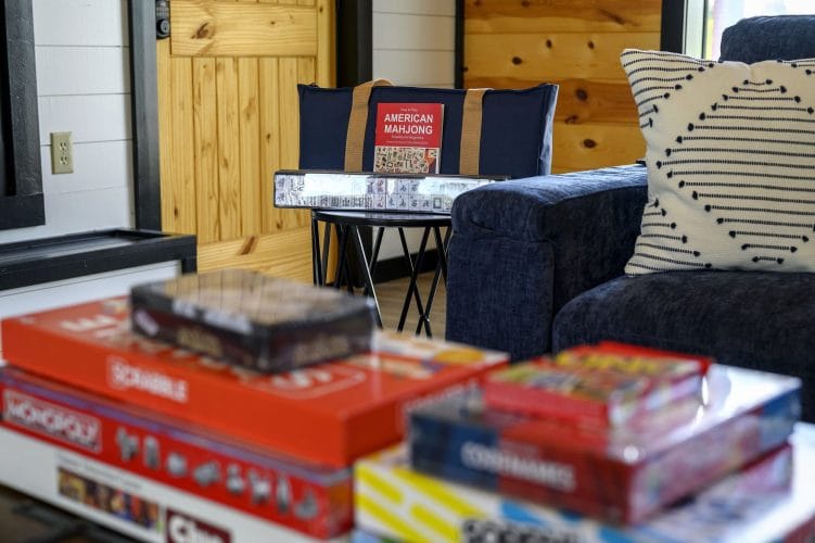 Close view of board games and an American Mahjong set beside a blue sofa