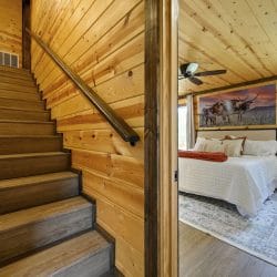Wood stairs with a handrail beside the main-floor bedroom