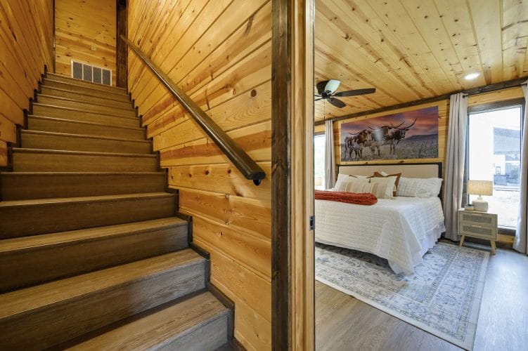 Wood stairs with a handrail beside the main-floor bedroom