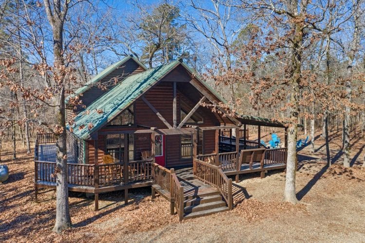 Front of the cabin with a green roof, stairs and porch (same view as photo 30, cropped square)