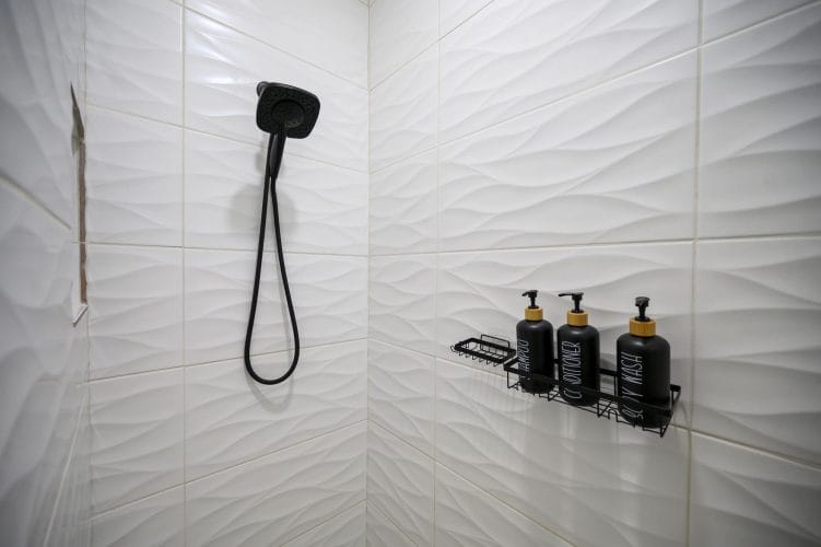 Shower with wavy white tile and black fixtures