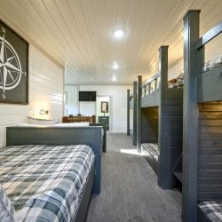 Bunk loft seen from one end, with a plaid daybed in front