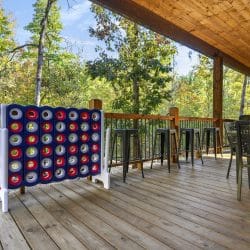 Giant Connect 4 game on the deck with a dining table beyond