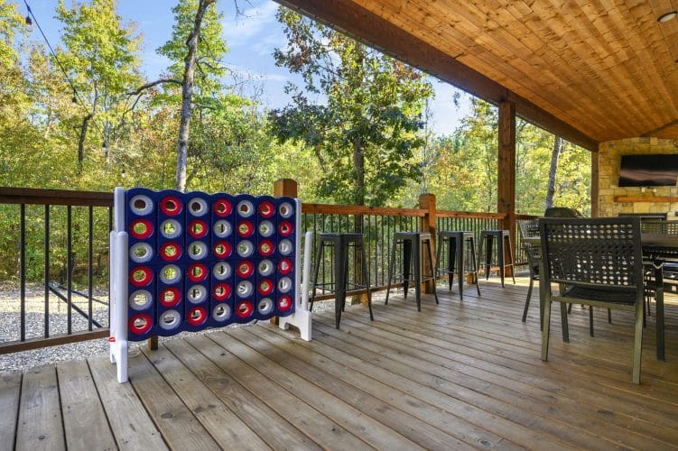 Giant Connect 4 game on the deck with a dining table beyond
