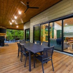Covered deck with a dining table, a grill and sliding doors into the kitchen