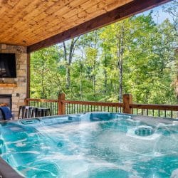 Hot tub in front of the stone fireplace on the deck