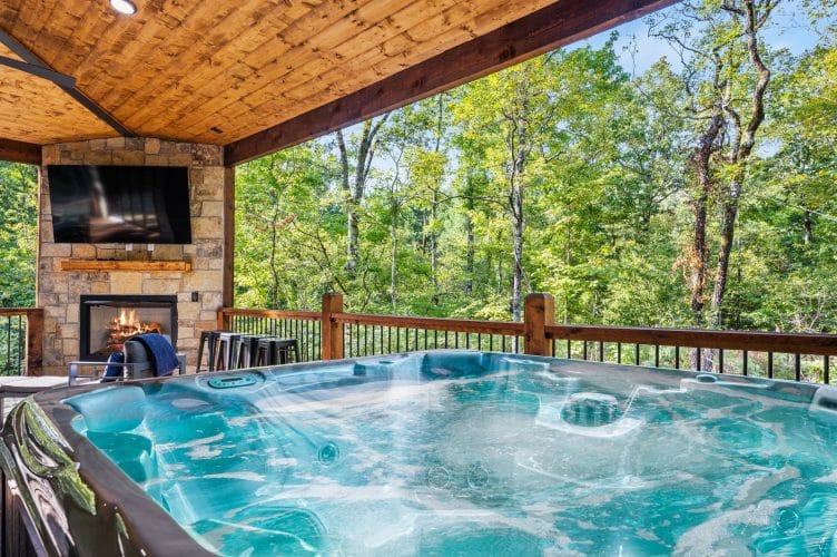 Hot tub in front of the stone fireplace on the deck