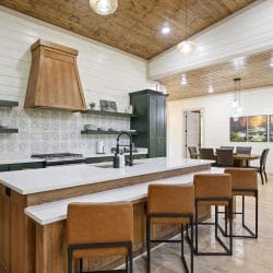 Kitchen island with leather stools, a dining table in the next room