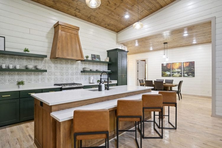 Kitchen island with leather stools, a dining table in the next room