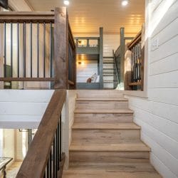 Open stairs with a railing leading up to the loft, with bunks visible at the top