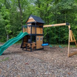 Playset with a green slide, a cedar tower and swings