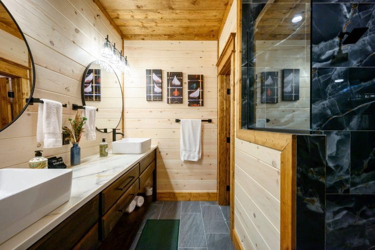 Double vanity beside a black tile shower
