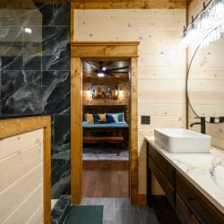 Vanity and shower with a bedroom visible through the doorway