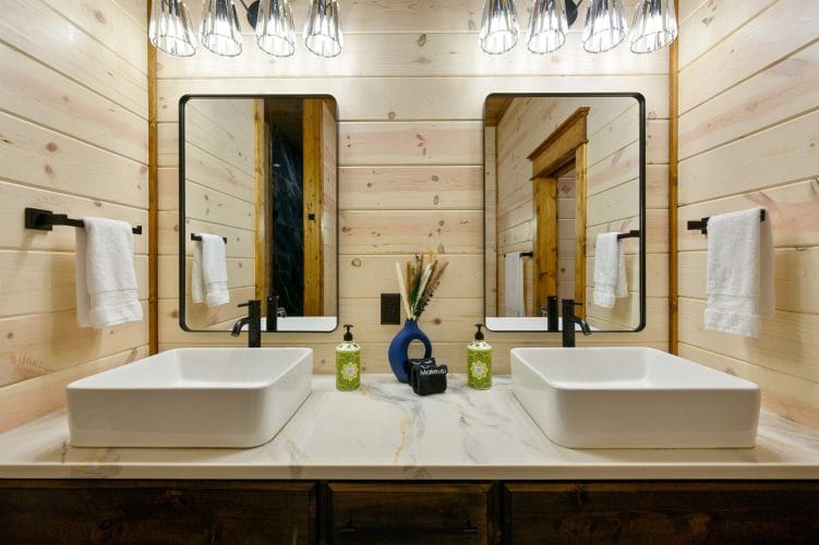 Double vanity with two vessel sinks and black-framed mirrors