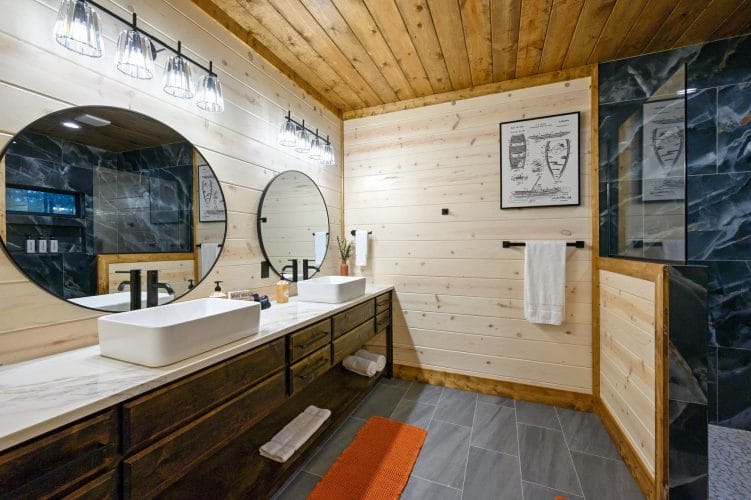 Double vanity with round mirrors and a shower at the right