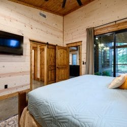 Same king bedroom with a wall TV and glass doors to the patio