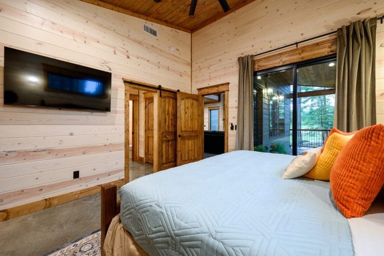 Same king bedroom with a wall TV and glass doors to the patio