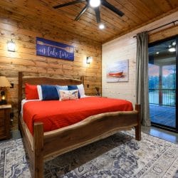 King bed with a red cover and a 'Lake Time' sign on the wall