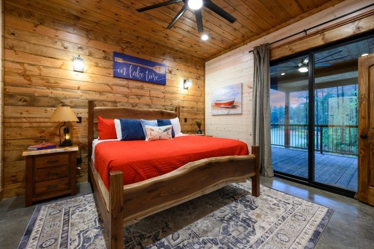 King bed with a red cover and a 'Lake Time' sign on the wall
