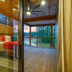 Sliding glass door from the bedroom to a deck looking out at the water