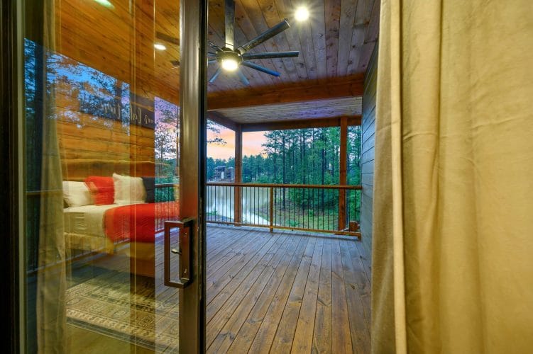 Sliding glass door from the bedroom to a deck looking out at the water