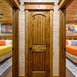 Hallway door between two bedrooms, one with yellow and one with orange bedding