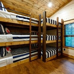 Triple-stacked bunks with navy-striped bedding