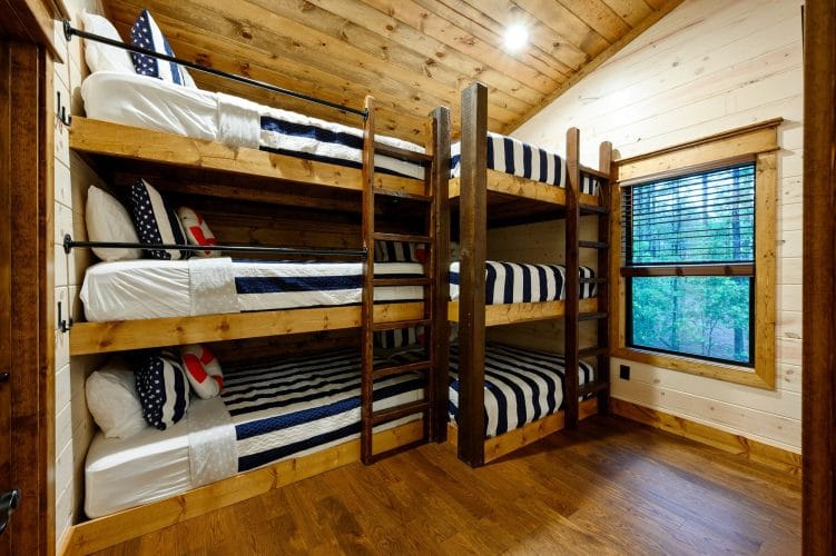 Triple-stacked bunks with navy-striped bedding