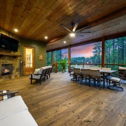 Covered deck with a long dining table, fireplace and loungers