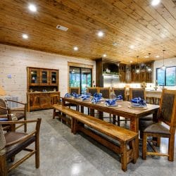 Long wood dining table with benches and chairs set with blue napkins