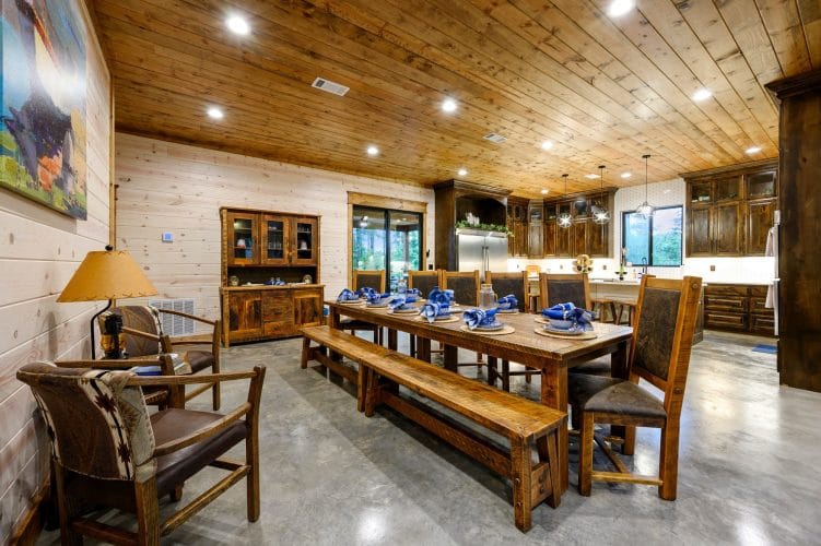 Long wood dining table with benches and chairs set with blue napkins