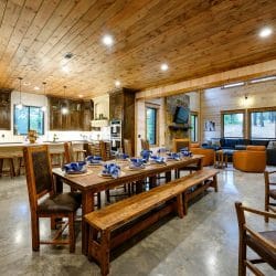 Dining table and benches with the kitchen and living room beyond