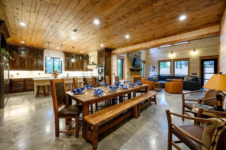 Dining table and benches with the kitchen and living room beyond