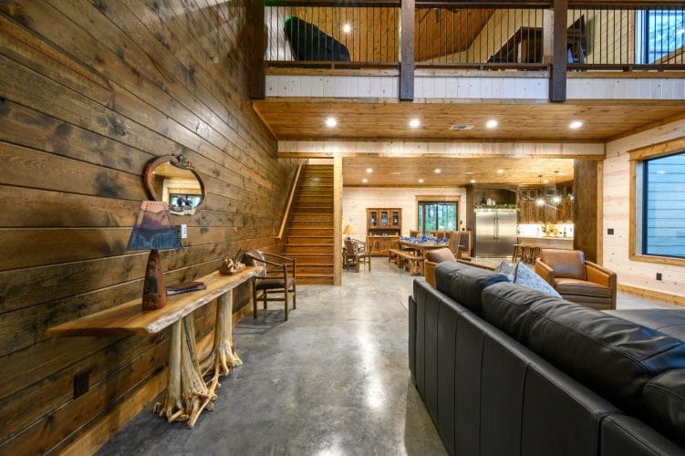 Open main floor with a console table in front, loft above and the kitchen beyond
