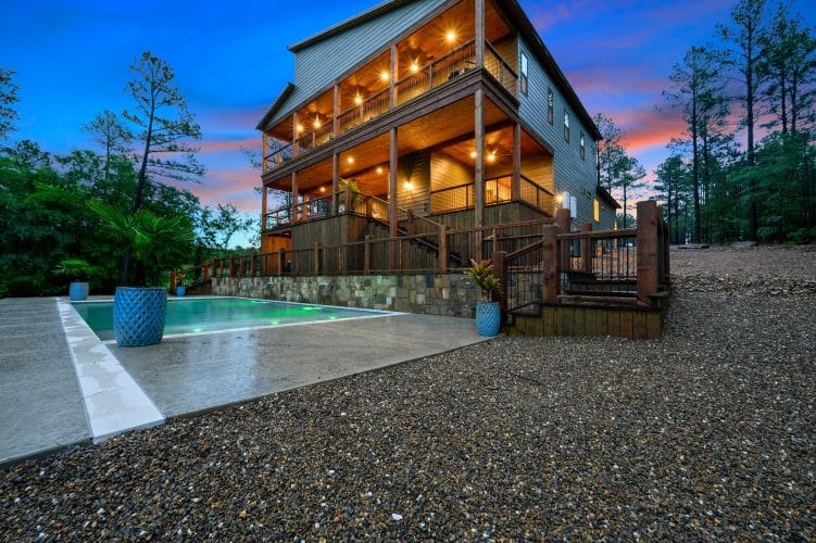 Multi-level decks above the pool, lit at dusk
