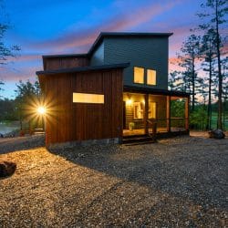 Side of the house in dusk light with a lit door