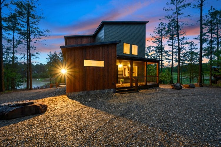 Side of the house in dusk light with a lit door