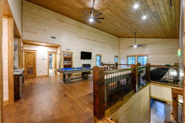 Upstairs game room overlooking the living room, with a pool table and shuffleboard