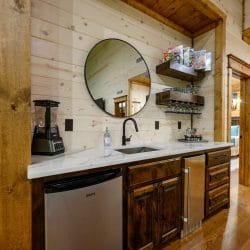 Wet bar nook with a sink, small fridge and blender upstairs