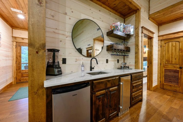 Wet bar nook with a sink, small fridge and blender upstairs